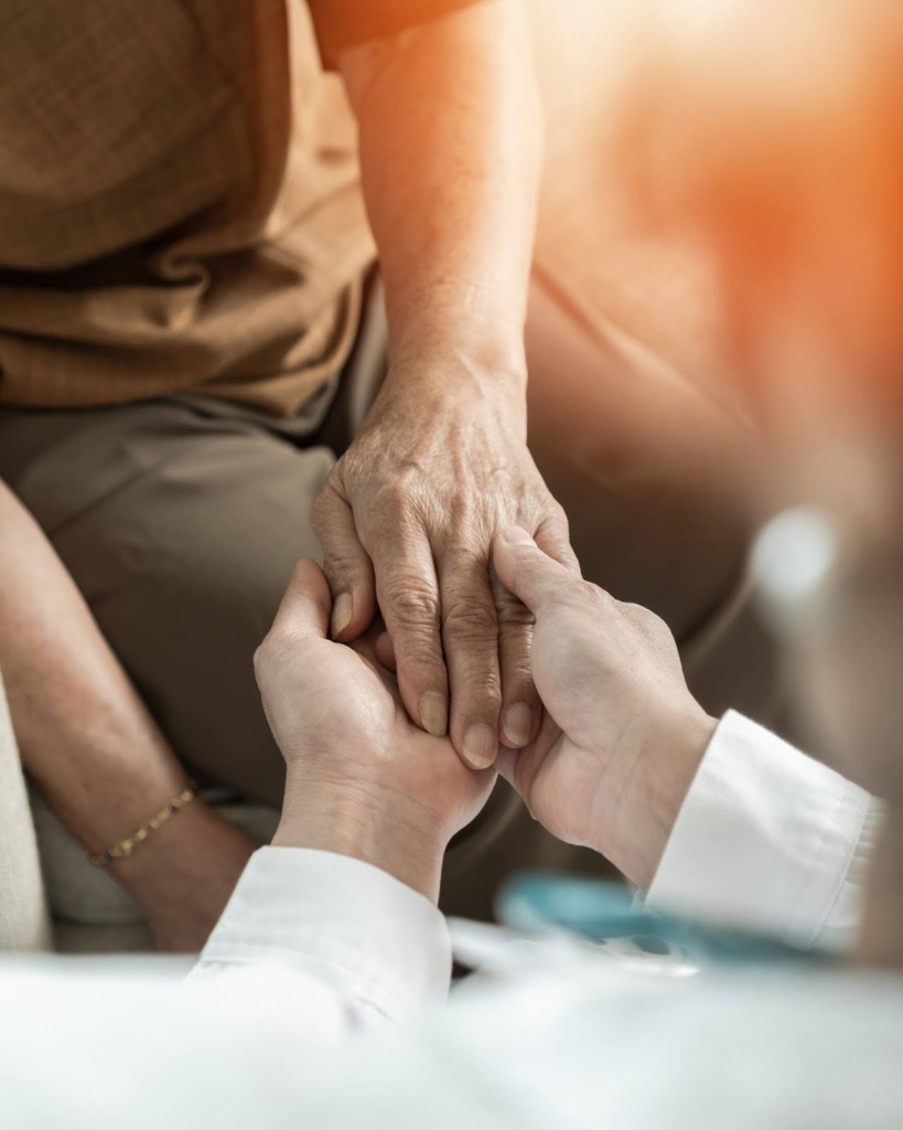 Younger person holding the hand of an older person
