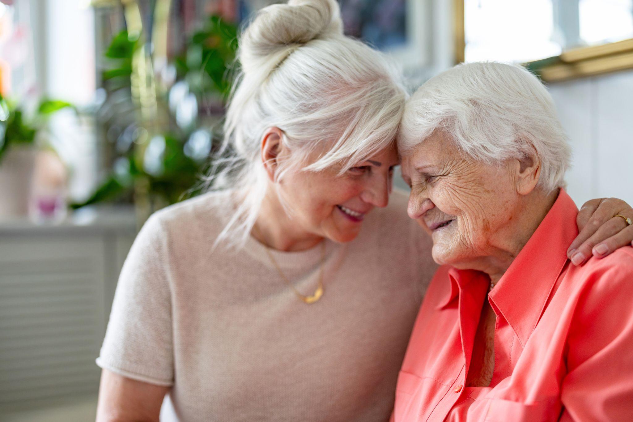 Happy senior woman with her adult daughter at home meeting about memory care in Downers Grove